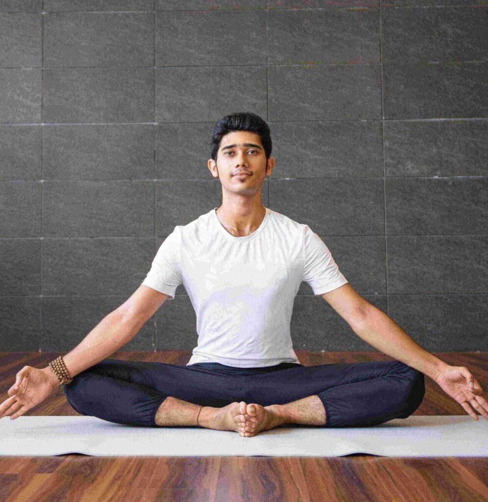 indian yogi sitting holding feet together gym scaled e1630066337269